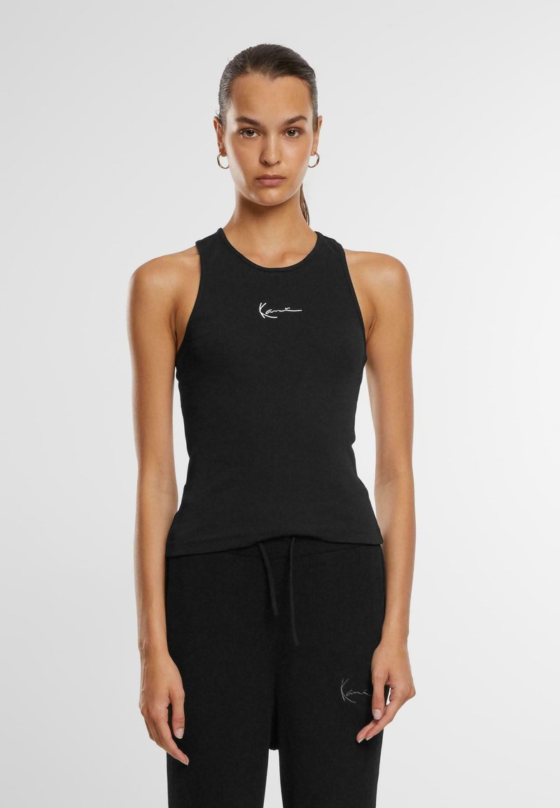 Must mustriba tank top sobiva kujundusega. Ümmargune kaelus, ilma varrukateta stiil, mis sisaldab valget logo, mis on tikitud rinda.