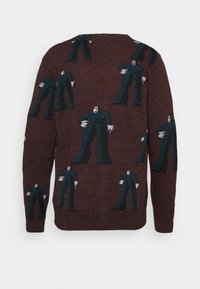 Stickad tröja med en mörkbrun bakgrund, som har ett upprepat mönster av figurer i teal och grått. Mjuk textur, rundad halsdesign.