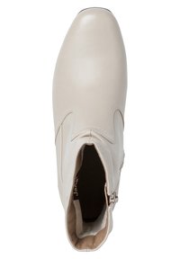 Bottine en cuir beige avec un bout en amande, coutures sur le côté et détail de fermeture éclair à l'intérieur ; doublure intérieure douce visible.