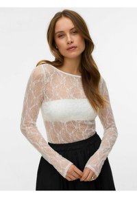 Dolga majica z dolgimi rokavi iz čipke, s polprozornim belim zgornjim delom in teksturiranim vzorcem, okrašena z bisernimi dodatki, z oprijetim belim korzetom.