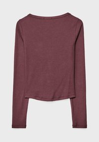 Maroon long-sleeve top with a rounded neckline, soft texture, slightly cropped hem, and simple stitching details at the shoulders.