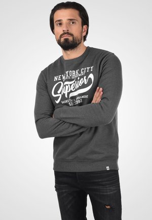 Gray sweatshirt with a crew neck, featuring white text print “NEW YORK CITY” and “Superior” in a curved font. Ribbed cuffs and hem.