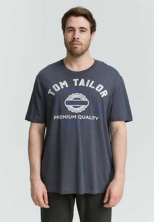 Donkergrijze katoenen t-shirt met korte mouwen. Bevat witte en blauwe tekst, waaronder "TOM TAILOR" en "PREMIUM QUALITY." Ontspannen pasvorm ontwerp.