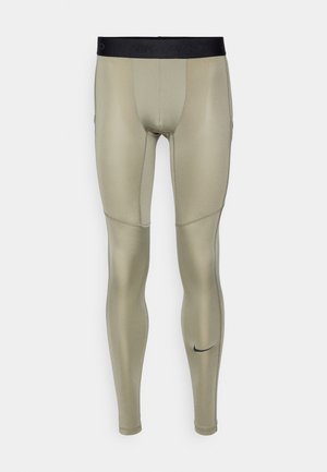 Aktiiviset legginsit, joissa on istuva malli, vaaleanoliivinväriset, valmistettu sileästä ja joustavasta materiaalista. Varustettu mustalla vyötärönauhalla ja pienellä mustalla logotiedolla.