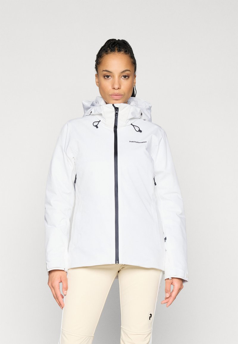 Casaco branco impermeável com colarinho alto e capuz ajustável, apresentando zíper e detalhes em preto. Textura suave, projetado para uso ao ar livre.