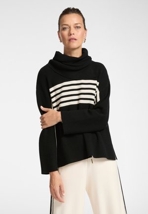 Jersey de cuello alto negro con rayas blancas horizontales en el pecho. Presenta mangas anchas y un ajuste suelto y texturizado.