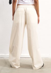 YOURTURN UNISEX - Nadrágok - off-white