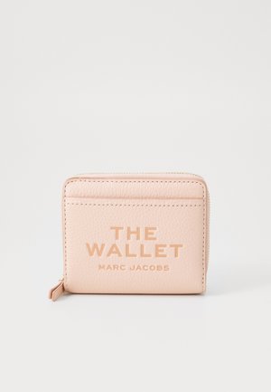 Billetera de cuero rosa con texto en relieve que dice "THE WALLET MARC JACOBS", con cierre de cremallera y ranuras para tarjetas en la parte posterior.