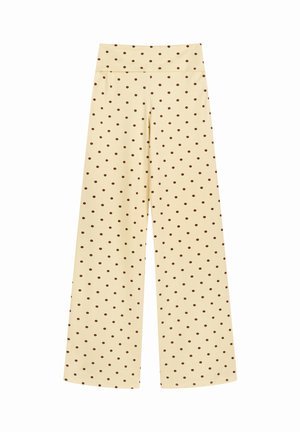 Høytlivs, vidbente kremfargede bukser med jevnt fordelte små brune polkadotter, vist på hvit bakgrunn.