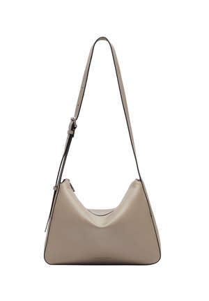 Beige Leder-Schultertasche mit geschwungenem Design, schwarzer Paspelierung und einem verstellbaren Tragegurt. Sie zeichnet sich durch eine glatte Textur und einen minimalistischen Stil aus.