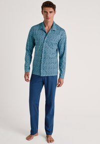 Heren loungewear set met een gestreept turquoise shirt met knoopsluiting en lange mouwen, gecombineerd met effen blauwe broek.