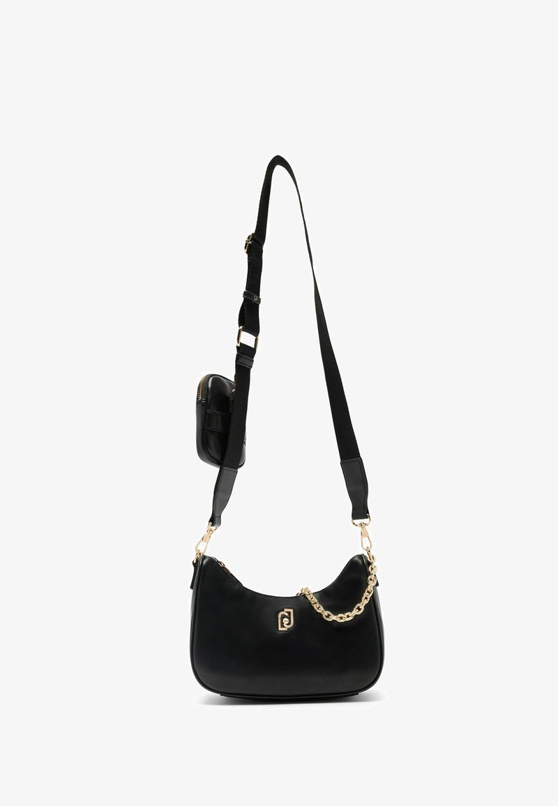 Borsa nera realizzata in pelle liscia con una forma curva, accentuata da una catena dorata e una tracolla regolabile. Include una piccola borsa attaccata.