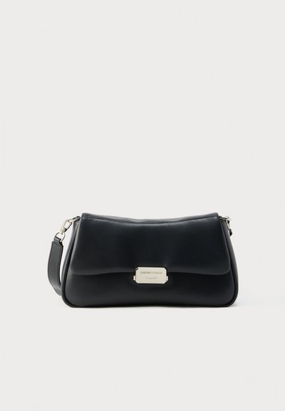 Black leather shoulder bag with a curved shape, featuring a gold-tone hardware tag and a detachable strap. Smooth texture.