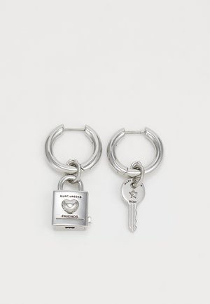 Pendientes de aro de plata con un charm de candado grabado con la palabra "AMIGOS" y un charm de llave inscrito con "MEJOR", ambos con acabados metálicos brillantes.