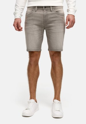 Pantaloni shorts in denim grigio chiaro con taglio dritto, cinque tasche, orlo arrotolato e dettagli di cucitura sottili, abbinati a sneaker bianche.