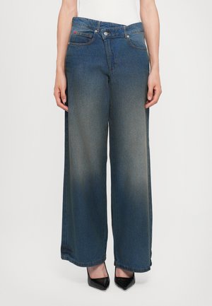 Wide-leg denim jeans in a dark blue wash, featuring a mid-rise waist, two front pockets, and a subtle faded effect.