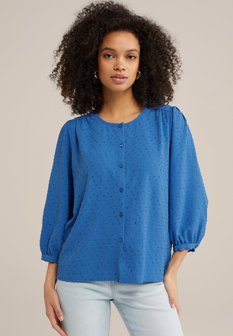 Blusa blu con bottoni, dal collo rotondo, maniche a sbuffo, tessuto dalla texture e piccoli punti in rilievo su tutta la superficie. Adatta per un look casual.