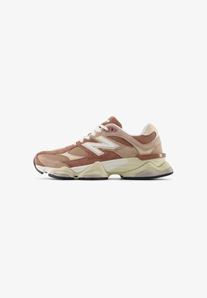 Braune und beige sportliche Sneakers aus Wildleder und Mesh-Materialien, runde Form, dicke Sohle, weiße Akzente und auffälliges Seitenlogo.
