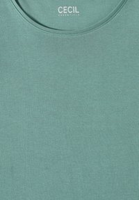 Helles teal Crewneck-T-Shirt mit dem weißen Textlogo "CECIL ESSENTIALS" auf der Innenseite des Kragens gedruckt.