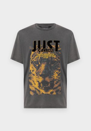 Camiseta de algodón gris con una gran impresión gráfica de leopardo, texto en negrita "JUST CAVALLI" en negro, y detalles desgastados para un aspecto envejecido.