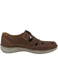 Brown leather shoe with cutout design, stitched accents, and a Velcro strap. Flexible light gray sole. Textured upper with ventilation holes.