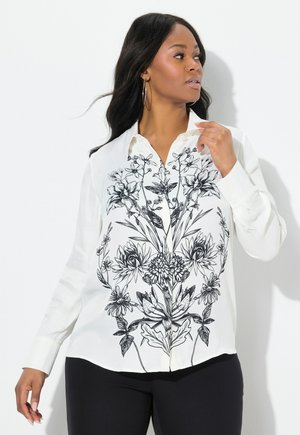 Chemise blanche à boutons avec un imprimé floral noir sur le devant, dotée d'un col et de manches longues. Tissu lisse avec une coupe décontractée.