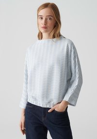 Blau-weiße gestreifte, locker sitzende Bluse mit rundem Ausschnitt, langen Ärmeln und gerafftem Saum. Der Stoff hat eine strukturierte Optik.