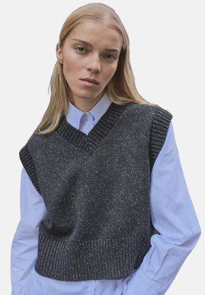 Grauer gestrickter ärmelloser Pullover mit V-Ausschnitt, strukturiertem Muster und gerippten Akzenten, getragen über einem hellblauen gestreiften Hemd mit Knöpfen.