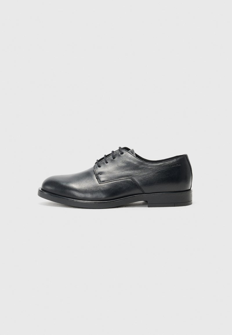 Zwarte leren dress shoe met een ronde neus, vlakke zool en zes gaatjes voor veters; gladde textuur en minimalistisch ontwerp.