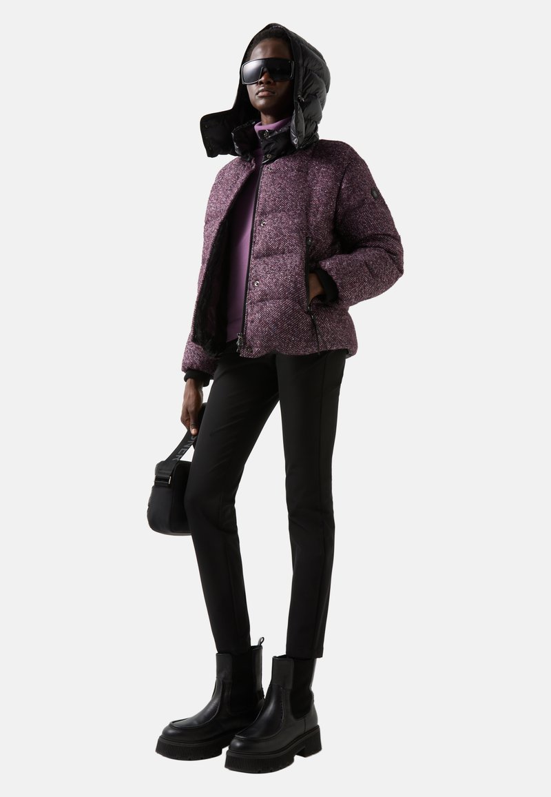 Paarse pufferjack met een glanzende zwarte capuchon, gecombineerd met een lavendeltop, zwarte slim fit broek en stevige zwarte enkellaarsjes. Soepele textuur, aansluitend ontwerp.