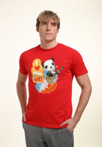 Red cotton T-shirt featuring a graphic design of a panda with a guitar, surrounded by hearts and colorful text saying "I ❤️ BEING ME!"