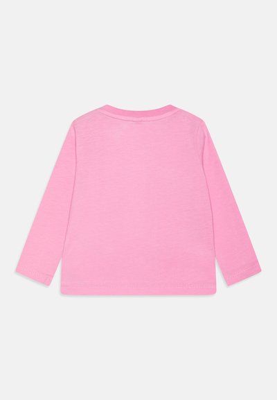 Una camicia a maniche lunghe di colore rosa uniforme, realizzata in morbido tessuto di cotone. Presenta un collo a giro e una semplice cucitura dell'orlo.