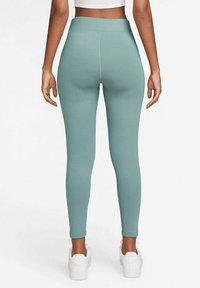 Högmidjade, stretchiga leggings i ljusgrön färg, tillverkade av ett mjukt tyg, välsittande design utan synliga mönster eller metalldetaljer.