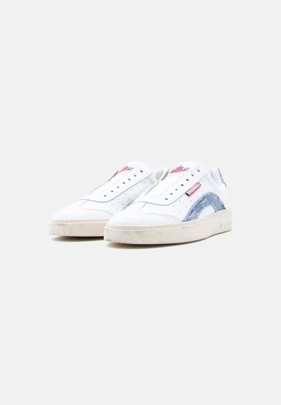 Paire de baskets basses blanches avec des accents en denim bleu clair et des étiquettes de logo rouges, positionnées côte à côte sur un fond blanc uni.