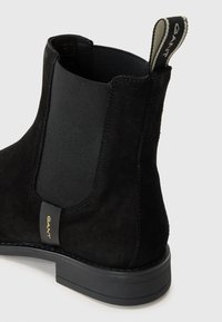 Bottines Chelsea en suède noir avec des panneaux latéraux élastiques, un talon noir texturé et un accent du logo GANT sur la languette du talon.