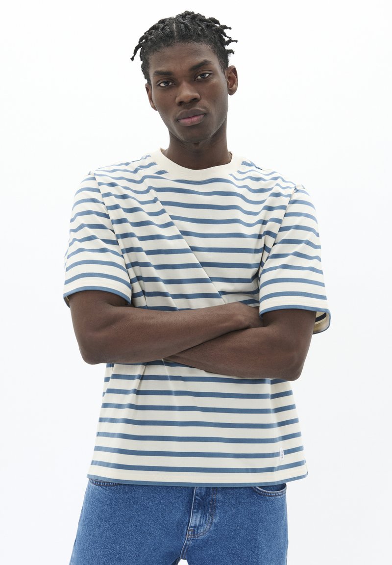 Striped t-shirt in cotton blend, featuring blue and cream horizontal stripes, short sleeves, and a crew neckline. Notable brand tag at hem.