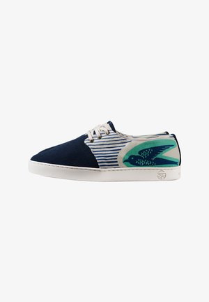Baskets bleu marine et blanches avec lacets blancs, motif rayé et graphique d’oiseau bleu sarcelle sur le talon, semelle en caoutchouc blanche, vue de côté.
