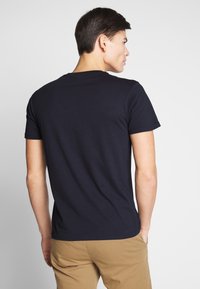 Marineblauwe katoenen t-shirt met ronde hals en korte mouwen, voorzien van een eenvoudige, gladde structuur en een klassieke pasvorm.
