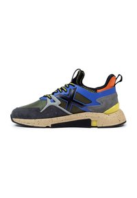 Zapatillas que presentan una combinación de malla verde y ante gris, acentos en negro y azul, suela amarilla neón y una media suela beige moteada.