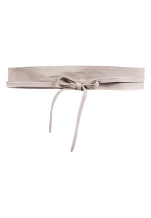 Světle béžový kožený pásek kolem pasu s mašlovým uzlem uvázaným vpředu a se dvěma dlouhými konci visícími dolů.