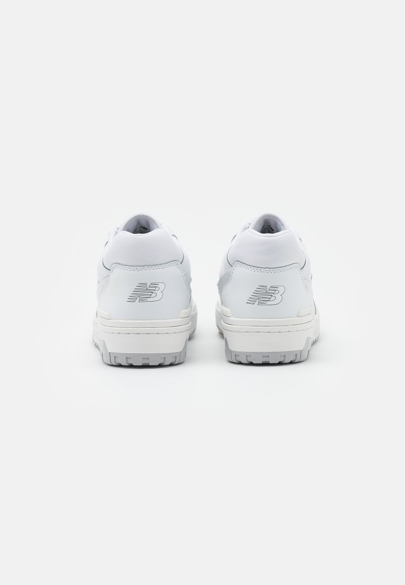 Baskets blanches avec un cuir supérieur texturé, bout rond et col rembourré. Présente le logo "NB" en argent sur le talon et une semelle en caoutchouc.