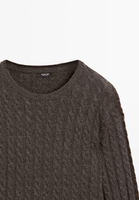 Maglione grigio scuro a maglia grossa con scollatura rotonda e tessuto testurizzato. Etichetta visibile all'interno del colletto, che indica il marchio.