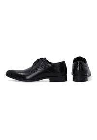Czarne skórzane buty wizytowe o gładkiej fakturze, eleganckim designie, zaokrąglonym nosku i minimalnym sznurowaniu. Posiadają niski obcas i gumową podeszwę.