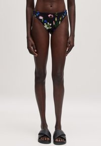 Blumen-Bikiniunterteil mit schwarzem Hintergrund und bunten Blumenmotiven. Das Design ist tief geschnitten, aus glattem Stoff und bietet minimalen Halt.