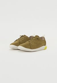 Adidași verzi din suede cu un finisaj texturat, având tălpi din cauciuc alb și un mic accent galben pe călcâi. Design clasic cu șireturi.