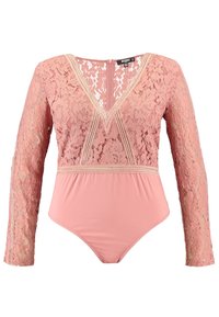 Body in pizzo rosa con maniche lunghe, scollatura a V profonda e parte inferiore liscia con dettagli in pizzo. Motivo floreale in pizzo su tutta la superficie.