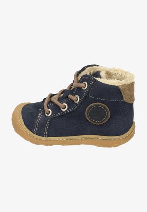 Botas de cuero azul marino con forro de pelaje, cordones marrones y suela de goma color beige. Presentan un logo en el costado y detalles de costura.