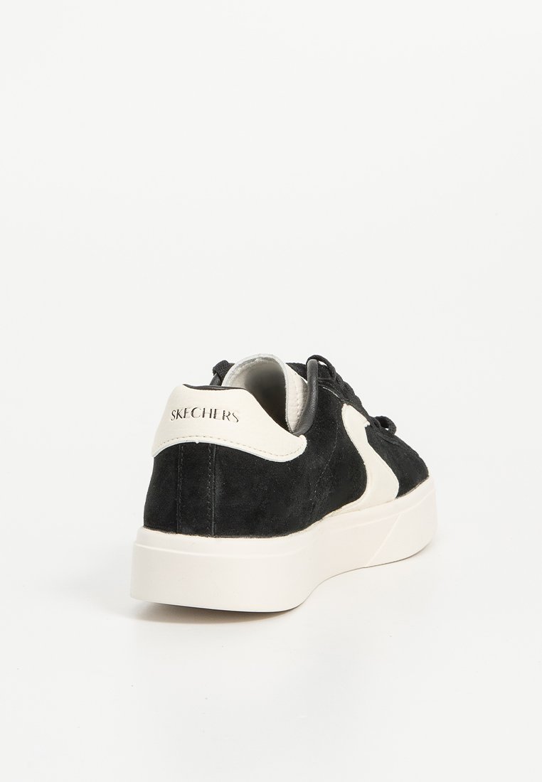 Schwarze Wildleder-Sneaker mit einem weißen Akzentpaneel, Schnürverschluss und einer glatten Gummisohle. Verfügt über dezente Markenkennzeichnung an der Ferse.
