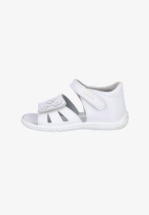 Sandalia blanca para niño/a con correas ajustables de velcro, detalles calados y un pequeño diseño floral en la correa de los dedos, mostrada de perfil lateral.