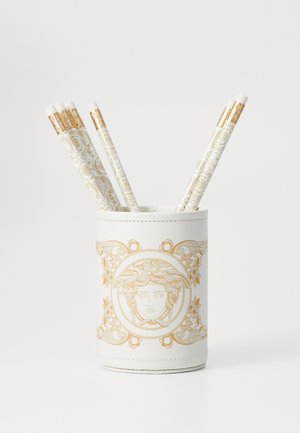 Porte-stylo blanc avec un design décoratif doré comportant un motif central de visage. Contient cinq stylos à motifs avec des accents dorés.